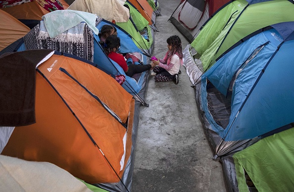-Des membres d'une famille de demandeurs d'asile restent dans une tente au refuge pour migrants Juventud 2000 à Tijuana, dans l'État de Baja California, au Mexique, le 3 avril 2020 lors de la pandémie du nouveau coronavirus COVID-19. Photo de Guillermo ARIAS / AFP via Getty Images.