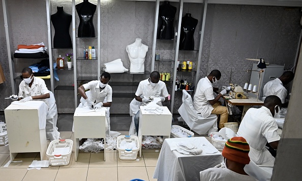 -Des ouvriers confectionnent des masques faciaux dans l'atelier de Roger Bango, créateur de mode ivoirien, converti en confectionneur de masques depuis l'apparition du coronavirus COVID-19, à Abidjan le 9 avril 2020. Photo par ISSOUF SANOGO / AFP via Getty Images.