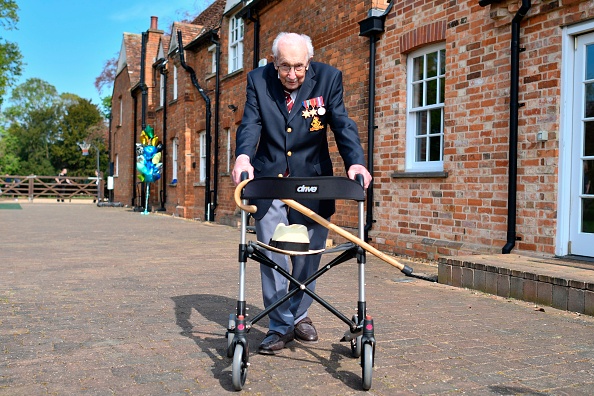 -Le vétéran britannique de la Seconde Guerre mondiale, le capitaine Tom Moore, 99 ans, pose avec son déambulateur de marche faisant un tour de son jardin dans le village de Marston Moretaine, à 80 kilomètres au nord de Londres, le 16 avril 2020. Photo de Justin TALLIS / AFP via Getty Images.
