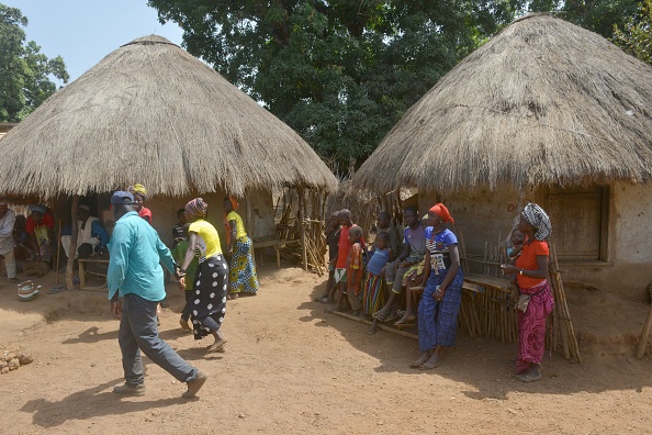 -Les habitants de Bouramaya Sousou, près du barrage de Souapiti se tiennent dans leur village, en Guinée le 3 mars 2020. Quelque 16 000 personnes doivent d'abord déménager, car le réservoir du barrage va inonder la brousse isolée où ils vivent. Photo par CELLOU BINANI / AFP via Getty Images.