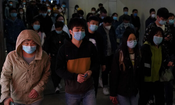 Des banlieusards portent des masques de protection à la sortie d'un train dans une station de métro aux heures de pointe à Pékin, en Chine, le 20 avril 2020. (Lintao Zhang/Getty Images)
