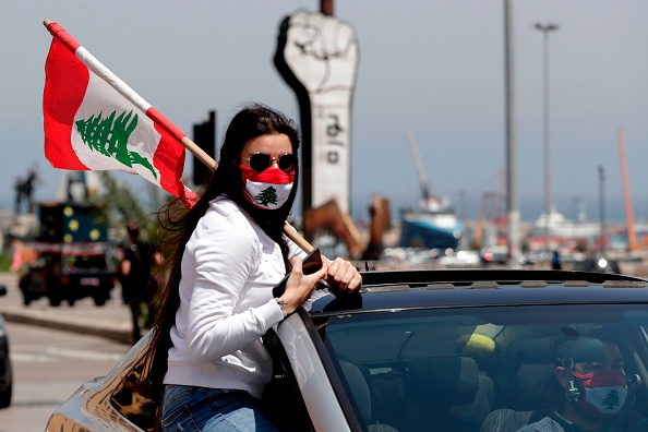 Une manifestante anti-gouvernement tient le drapeau national lors d'une manifestation dans la capitale libanaise à Beyrouth le 22 avril 2020, au milieu d'une crise économique exacerbée par la pandémie de coronavirus. (Photo : ANWAR AMRO/AFP via Getty Images)