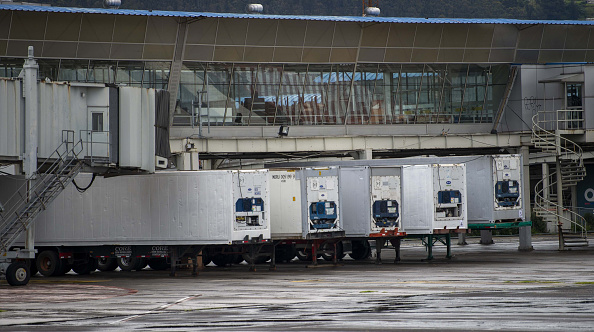 -Des camions de réfrigération qui serviront de morgue temporaire sont stationnés un centre de congrès où un hôpital de campagne de 370 lits pour les patients atteints de coronavirus COVID-19 est en construction à Quito le 23 avril 2020. Photo de RODRIGO BUENDIA / AFP via Getty Images.