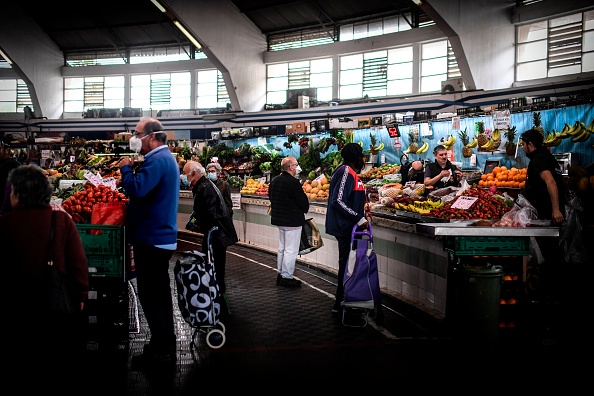 Les clients portant des masques faciaux achètent des fruits et légumes sur le marché local de Benfica lors d'un confinement national pour empêcher la propagation de la maladie COVID-19, à Lisbonne le 23 avril 2020.(Photo : PATRICIA DE MELO MOREIRA/AFP via Getty Images)
