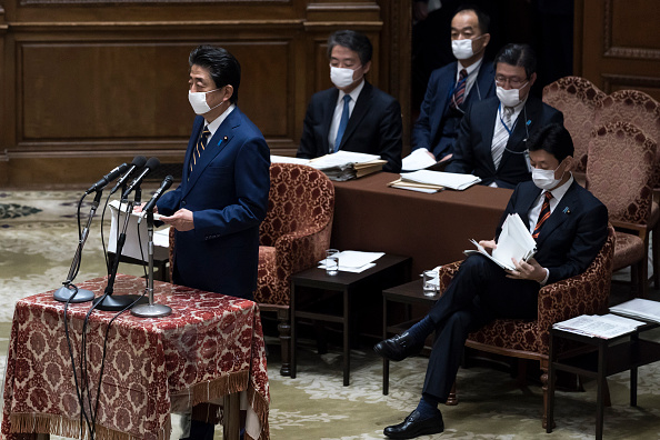 -Le Premier ministre japonais Shinzo Abe, portant un masque facial, prend la parole lors d'un comité à la chambre basse du Parlement le 07 avril 2020 à Tokyo, au Japon. Abe a annoncé hier que le gouvernement avait l'intention de déclarer l'état d'urgence qui couvrira 7 des 47 préfectures du Japon, y compris Tokyo et Osaka. Photo de Tomohiro Ohsumi / Getty Images.