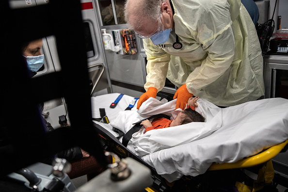 Un enfant ayant de la fièvre est emmené à l'hôpital en ambulance. (John Moore/Getty Images)