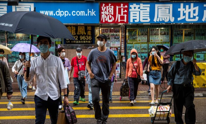 Jeff Rotmeyer (au c.), fondateur et PDG d'ImpactHK, traverse une rue après avoir distribué des masques faciaux, des désinfectants pour les mains, de la nourriture et des boissons aux sans-abri et aux gens qui en avaient besoin à Hong Kong, le 28 mars 2020. (Isaac Lawrence/AFP via Getty Images)