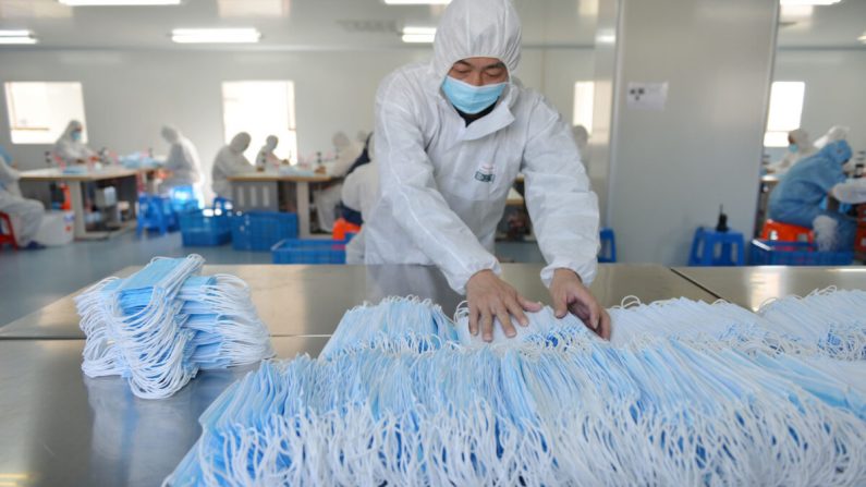Un ouvrier d'une usine de Nanjing, dans la province chinoise du Jiangsu, trie des masques faciaux le 18 février 2020. (STR/AFP via Getty Images)