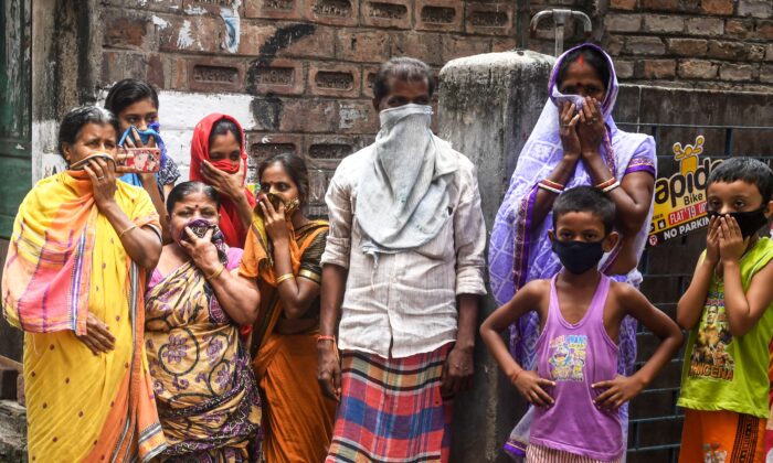 Des personnes protègent leur visage lors d'un verrouillage national imposé par le gouvernement à Kolkata, en Inde, le 24 avril 2020. (Dibyangshu Sarkar / / AFP via Getty Images)