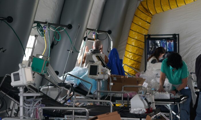 Des bénévoles installent un hôpital de campagne d'urgence dans Central Park le 30 mars 2020. On y voit des fournitures médicales et des lits à l'intérieur d'une tente. (Bryan R. Smith / AFP via Getty Images)