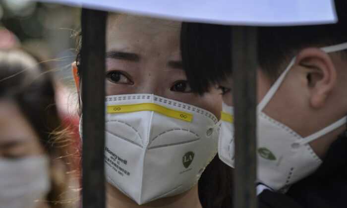 Une résidente de Wuhan réagit au départ d'une équipe d'assistance médicale de la province du Yunnan après avoir participé à l'effort de lutte contre le covid-19 à Wuhan, en Chine, le 18 mars 2020. (AFP via Getty Images)