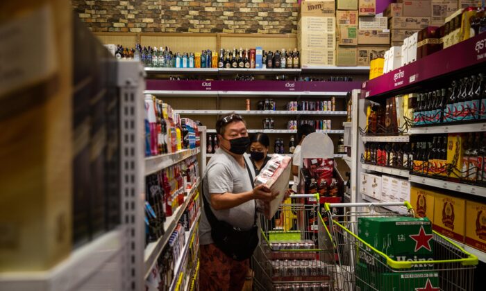 Des personnes portant des masques faciaux achètent des caisses de bière dans une épicerie de Bangkok, en Thaïlande, le 9 avril 2020. (Lauren DeCicca/Getty Images)
