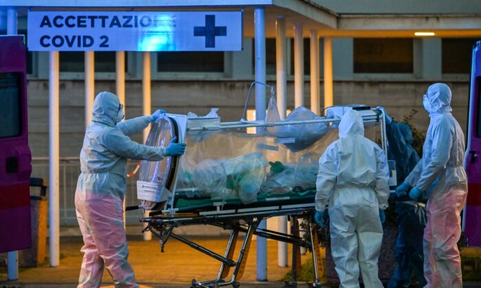 Le 16 mars 2020, des professionnels de la santé emmènent un patient en soins intensifs dans l'hôpital temporaire Columbus Covid 2, nouvellement construit pour lutter contre l'épidémie de COVID-19, à Rome, en Italie. (Andreas Solaro/AFP/Getty Images)