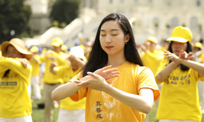 Les pratiquants de Falun Gong effectuent les exercices lors d'un rassemblement commémorant le 20e anniversaire de la persécution du Falun Gong en Chine, sur la pelouse ouest du Capitole, le 18 juillet 2019. (Samira Bouaou/The Epoch Times)