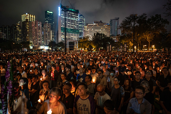 -Les gens tiennent des bougies alors qu'ils participent à une veillée aux chandelles pour commémorer le massacre de Tiananmen au Victoria Park le 4 juin 2019 à Hong Kong, Chine. Photo par Anthony Kwan / Getty Images.