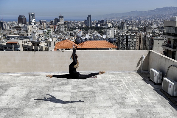 -Sherazade Mami, une danseuse et artiste professionnelle tunisienne de 28 ans au théâtre de danse de Caracalla et professeur à l'école de danse de Caracalla, pratique tout en portant un masque chirurgical sur le toit de son immeuble dans la banlieue est de la capitale du Liban, Beyrouth, le 4 avril 2020. Photo de JOSEPH EID / AFP via Getty Images.