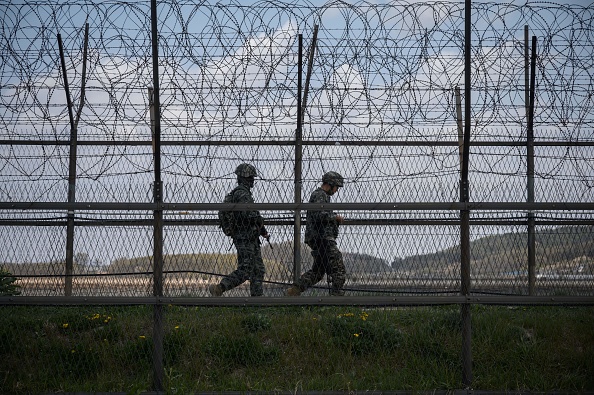 -Des soldats sud-coréens patrouillent le long d'une clôture en fil barbelé de la Zone démilitarisée (DMZ) séparant la Corée du Nord et la Corée du Sud, sur l'île sud-coréenne de Ganghwa le 23 avril 2020. Photo ED JONES / AFP via Getty Images.