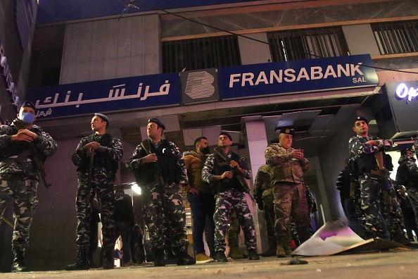 -Les forces de sécurité libanaises montent la garde devant l'entrée d'une succursale de la Fransabank à Sidon, dans le sud du Liban, le 25 avril 2020, après que des assaillants inconnus ont visé l'entrée de la banque avec un engin explosif. Photo de Mahmoud.