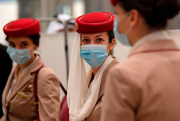 Les hôtesses de l'air d'un vol Emirates Airlines au départ de Londres arrivent à l'aéroport international de Dubaï le 8 mai 2020 durant la pandémie du Covid-19. (Photo : KARIM SAHIB/AFP via Getty Images)
