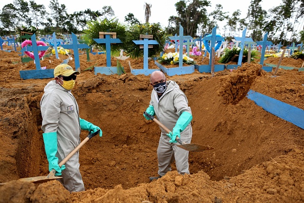 -Le Brésilien Ulisses Xavier, 52 ans, travaille depuis 16 ans au cimetière Nossa Senhora à Manaus, au Brésil, il creuse une tombe aux côtés d'un collègue le 8 mai 2020, au milieu de la nouvelle pandémie de coronavirus. Photo de MICHAEL DANTAS / AFP via Getty Images.