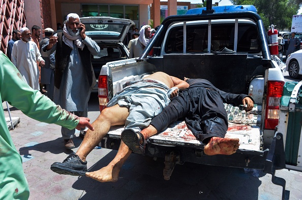 -Des hommes blessés sont transportés dans un camion vers un hôpital après un attentat-suicide lors des funérailles d'un commandant de police local à Nangarhar le 12 mai 2020. Photo de NOORULLAH SHIRZADA / AFP via Getty Images