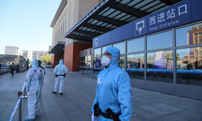 Des policiers montent la garde devant la gare de la ville de Jilin, qui est fermée en raison de l'épidémie du virus du PCC à Jilin, en Chine, le 13 mai 2020. (STR/AFP via Getty Images)