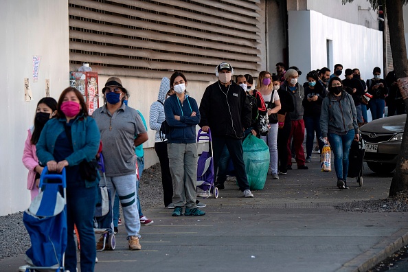 Les gens font la queue devant un supermarché à Santiago, deux jours avant le début d'une quarantaine totale dans la capitale chilienne pour aider à ralentir la propagation du nouveau coronavirus.  (Photo : MARTIN BERNETTI/AFP via Getty Images)