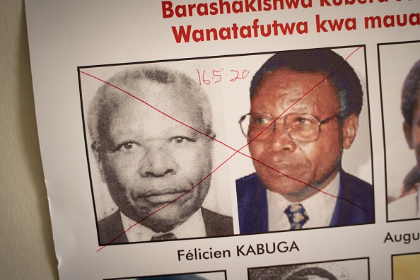 -La date de l'arrestation et une croix rouge sont écrites sur le visage de Félicien Kabuga, l'un des derniers suspects clés du génocide rwandais de 1994, sur une affiche recherchée au bureau de l'Unité de suivi des fugitifs du génocide à Kigali, Rwanda, le 19 mai. 2020. Photo by SIMON WOHLFAHRT/AFP via Getty Images.