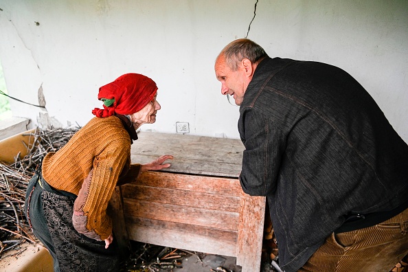 -Un Albanais du Kosovo, Fadil Rama, aide une femme serbe de 92 ans Vladica Dicic lui rend visite dans sa maison du village de Vaganesh le 21 mai 2020. Photo by ARMEND NIMANI/AFP via Getty Images.
