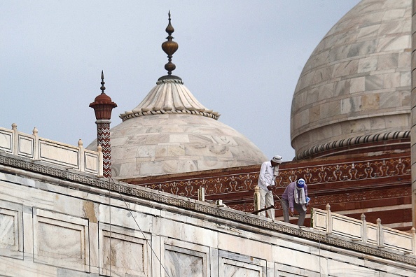 -Des travailleurs réparent la rambarde du Taj Mahal endommagée par une forte tempête de pluie à Agra le 30 mai 2020. Photo de Pawan Sharma / AFP via Getty Images.