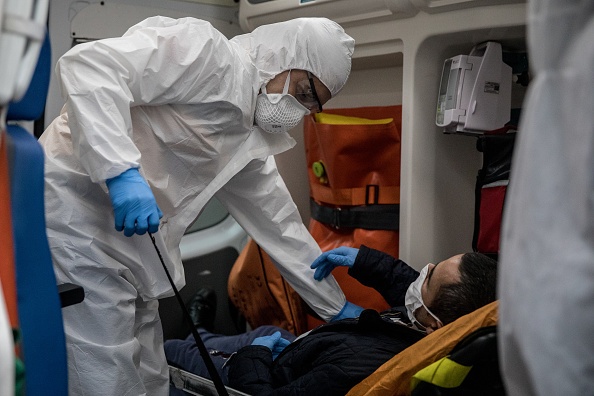 -Un ambulancier paramédical du 112 services de santé d'urgence de Turquie sécurise un patient présentant des symptômes de COVID-19 avant de le transporter à l'hôpital dans le quartier de la « zone rouge » le 04 mai 2020 à Istanbul, en Turquie. Photo de Chris McGrath / Getty Images.