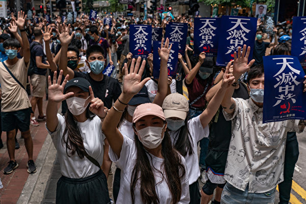 Une manifestation à Hong Kong contre la loi sur la sécurité nationale proposée par Pékin, le 24 mai 2020. Les manifestants brandissent cinq doigts symbolisant leurs revendications et tiennent des pancartes disant « Le ciel élimine le PCC ». (Anthony Wallace/AFP via Getty Images)