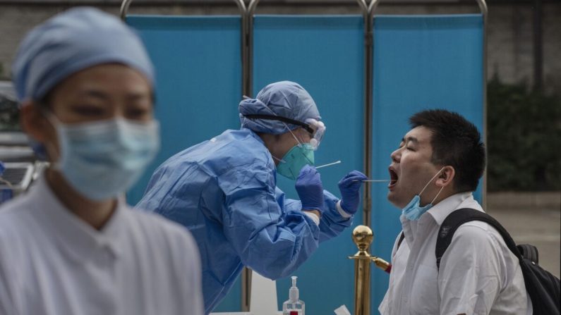 Un professionnel de la santé chinois effectue un test d'acide nucléique sur un journaliste couvrant les événements autour de l'Assemblée nationale populaire à Pékin, en Chine, le 28 mai 2020. (Kevin Frayer/Getty Images)