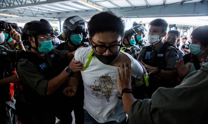 Des officiers de police arrêtent un manifestant pro-démocratie (C) lors d'une manifestation pro-démocratie appelant à l'indépendance de la ville de Hong Kong le 10 mai 2020. (Isaac Lawrence/AFP via Getty Images)