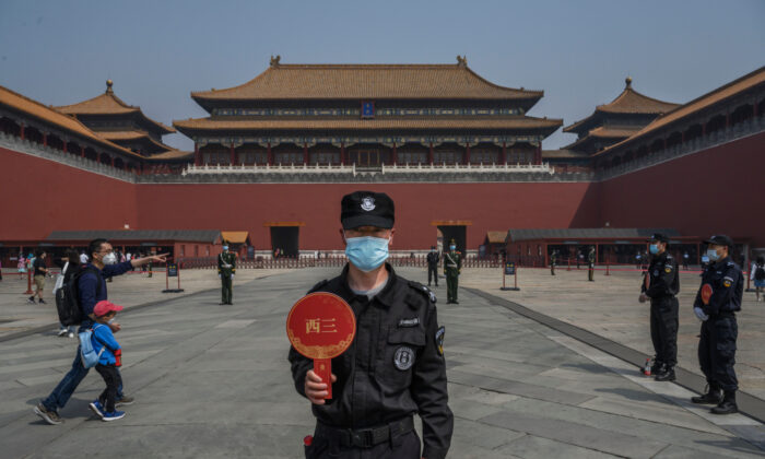 Un garde porte un masque de protection à l'entrée de la Cité interdite à Pékin lors de sa réouverture à un nombre limité de visiteurs, le 1er mai 2020. (Kevin Frayer/Getty Images)