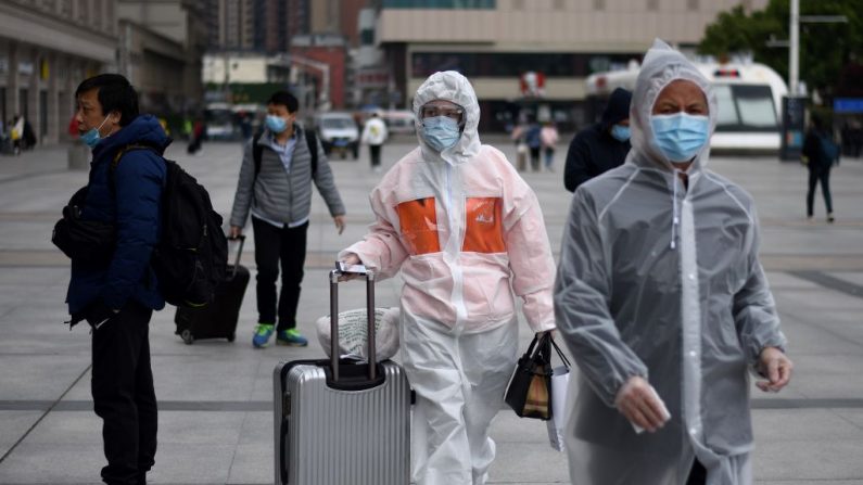 Des passagers munis de masques de protection arrivent à la gare ferroviaire de Hankou à Wuhan, en Chine, le 11 avril 2020. (Noel Celis/AFP via Getty Images)