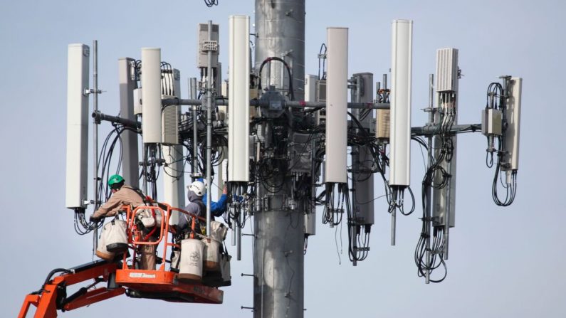 Une équipe travaille sur une tour de téléphonie cellulaire pour la moderniser et la rendre compatible avec le nouveau réseau 5G à Orem, dans l'Utah, le 10 décembre 2019. (George Frey/AFP via Getty Images)
