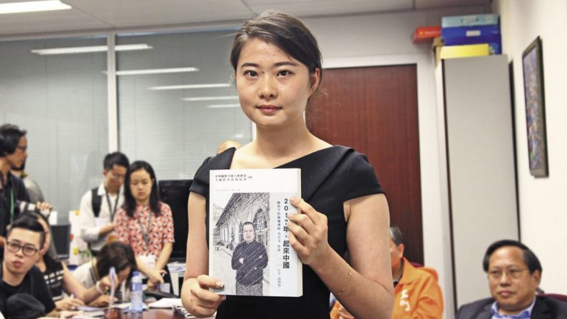 Grace Geng, la fille de Gao Zisheng, tient un exemplaire du nouveau livre de son père lors de la cérémonie de lancement du livre à Hong Kong le 16 juin 2016. (Stone Poon/The Epoch Times)