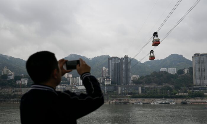 Un homme prenant des photos dans la ville de Chongqing, dans le sud-ouest de la Chine, le 22 mars 2019. (WANG ZHAO/AFP via Getty Images)