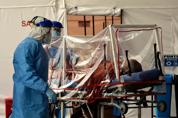 -Un patient qui a été testé positif au nouveau coronavirus est transporté sur une civière dans la salle d'urgence de l'hôpital IESS à Quito le 18 avril 2020. Photo de RODRIGO BUENDIA / AFP via Getty Images.