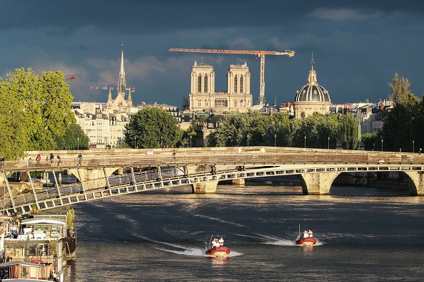 -Des pompiers patrouillent sur des embarcations le long de la Seine à Paris, alors que les travaux se poursuivent sur l'incendie qui a endommagé la cathédrale de Notre-Dame en arrière-plan. Photo de Ludovic MARIN / AFP via Getty Images.