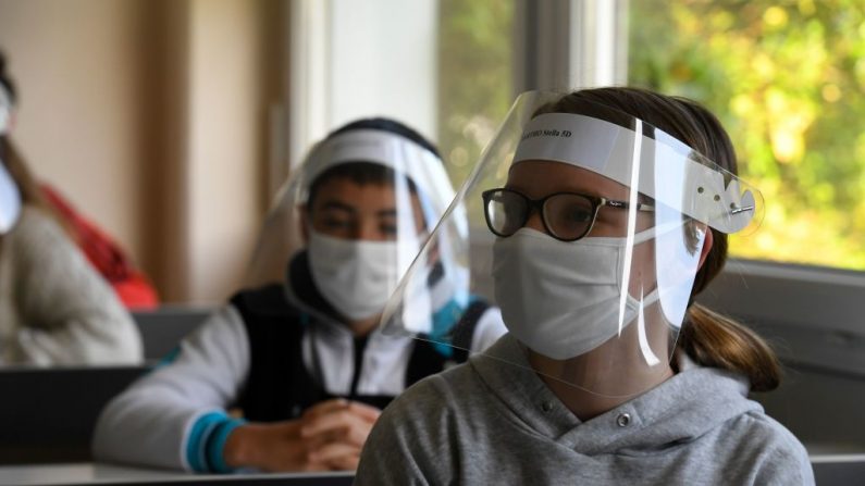 Des écoliers portant des masques de protection buccale et des écrans faciaux au collège Claude Debussy à Angers, dans l'ouest de la France, le 18 mai 2020.  (Photo by DAMIEN MEYER/AFP via Getty Images)
