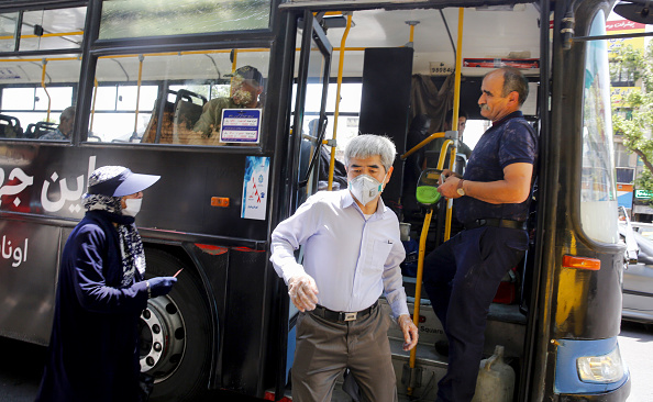 -Illustration- Un Iranien, porte un masque protecteur, sort d'un bus dans la capitale, Téhéran, le 26 mai 2020. Photo de STRINGER / AFP via Getty Images.