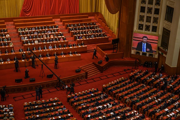 -Le président chinois Xi Jinping est vu sur un grand écran alors que les délégués du Parti communiste participent à une session après avoir voté sur un nouveau projet de loi de sécurité pour Hong Kong lors de la séance de clôture. Photo de Kevin Frayer / Getty Images.