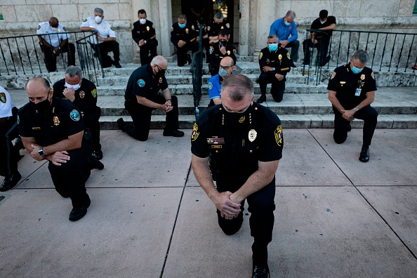 Depuis la mort de George Floyd, de nombreux policiers s'agenouillent afin de soutenir les manifestants (EVA MARIE UZCATEGUI/AFP via Getty Images)