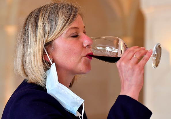 -Une femme avec un masque enlevé goûte du vin dans le domaine viticole Château Montrose à Saint-Estephe près de Bordeaux le 4 juin 2020 lors d'une dégustation de vins de Bordeaux « primeurs » selon les règles sanitaires. Photo de GEORGES GOBET / AFP via Getty Images.