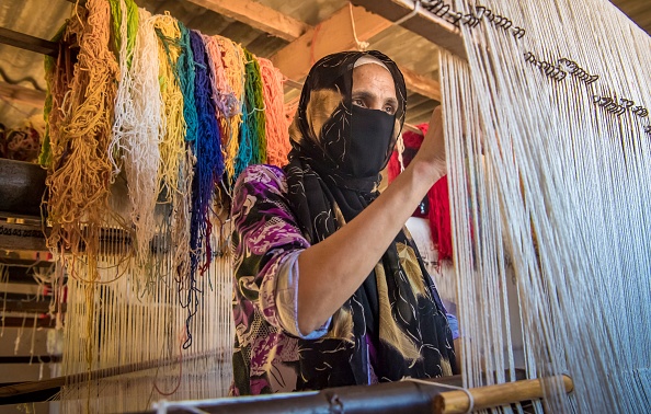 -Un tisserand marocain crée un tapis dans un atelier de la ville de Sale, au nord de la capitale Rabat, le 3 juin 2020. Les artisans marocains sont privés de revenus depuis près de trois mois à cause de la pandémie COVID-19. Photo par FADEL SENNA / AFP via Getty Images.
