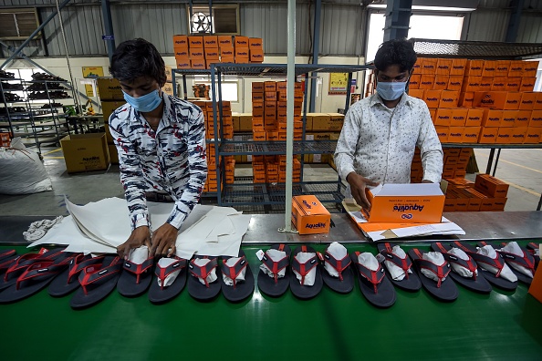 -Une grave pénurie de travailleurs a transformé le rugissement des machines en un ronflement doux dans une usine de chaussures près de New Delhi,  après l'exode des migrants ruraux provoqué par le verrouillage du virus. Photo par Money SHARMA / AFP via Getty Images.