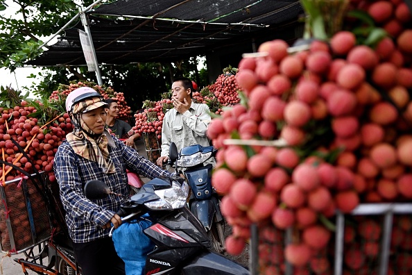 -Les agriculteurs vietnamiens arrivent avec des litchis récoltés pour les vendre aux commerçants nationaux sur un marché de gros du district de Luc Ngan dans la province de Bac Giang au Vietnam le 9 juin 2020. Photo de Manan VATSYAYANA / AFP via Getty Images.