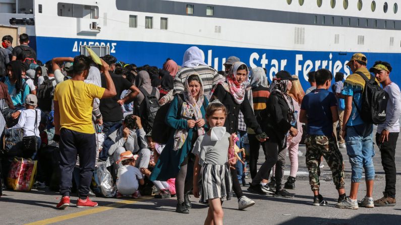 -Les migrants se rassemblent au port de Mytilène sur l'île de Lesbos après avoir reçu un document de libre circulation sur le continent grec, le 10 juin 2020. Photo de Manolis LAGOUTARIS / AFP via Getty Images.